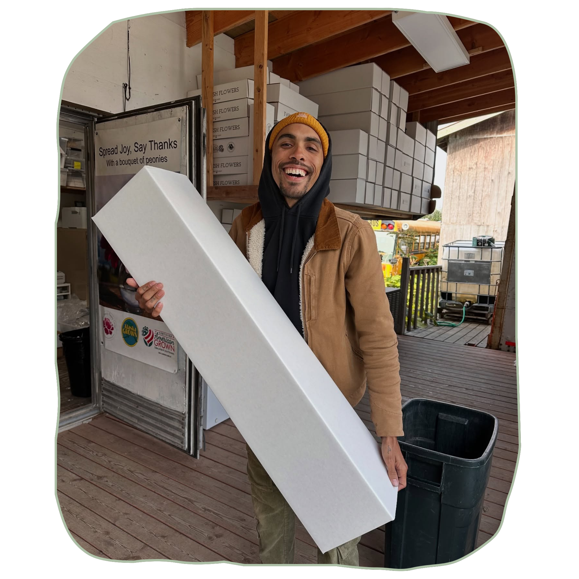 Man holding a large white box in an outdoor setting with boxes and a truck in the background | Packhouse Manager | Job Opportunities | Homer, AK